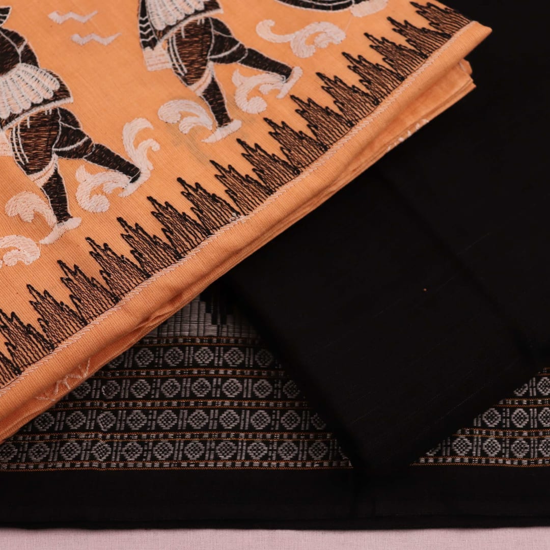 Detailed view of a Sambalpuri cotton dress material in brown and black, showcasing the doll-patterned design on the body.