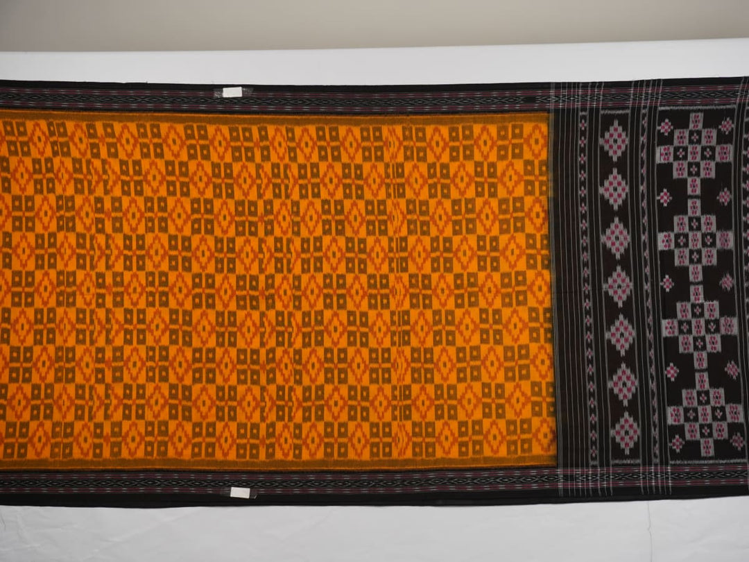 Professional styling of the yellow and black Sambalpuri cotton saree with traditional motifs shown on a model.