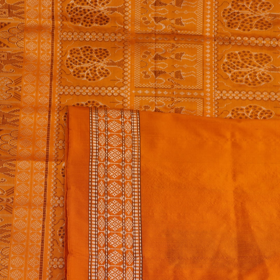 Close-up of Bomkai silk saree fabric texture in white with yellow butta pattern.