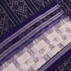 Model wearing a white Sambalpuri cotton saree with blue motifs, showcasing the drape and overall look.