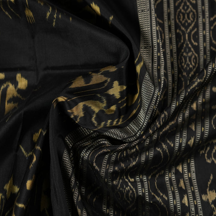 Close-up of the lustrous black Sambalpuri silk fabric, revealing its luxurious texture and fine weave.