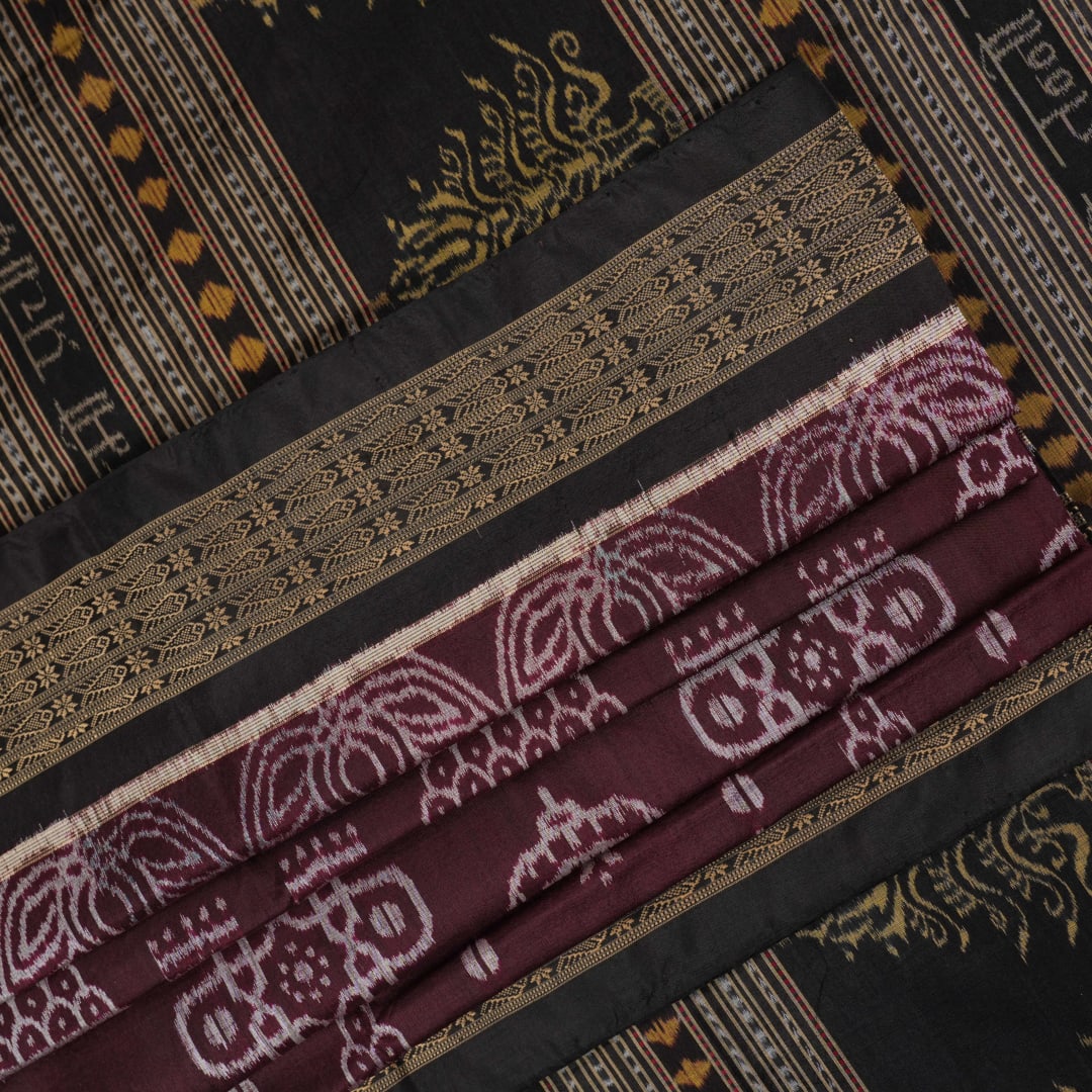 Micro close-up of the maroon Sambalpuri silk fabric, revealing its luxurious texture and handloom weave.