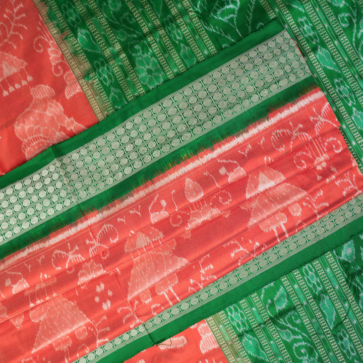 Close-up of the smooth, rich silk texture of the peach Sambalpuri saree with fine motifs.