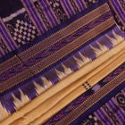 Woman draped in a cream and blue Khandua silk saree with butta pattern, showcasing the elegant drape and styling.