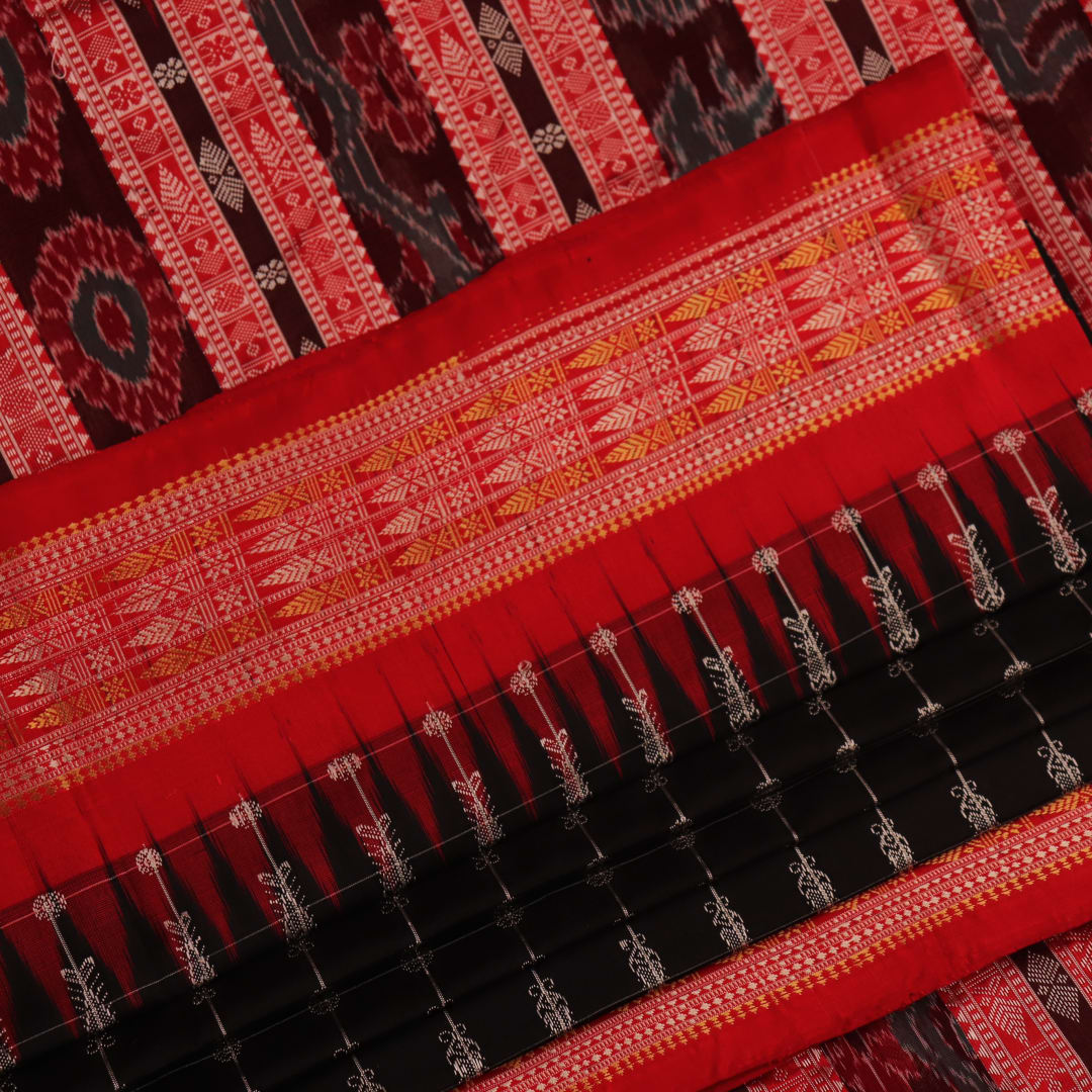 Close-up of black and red silk fabric texture with butta pattern.