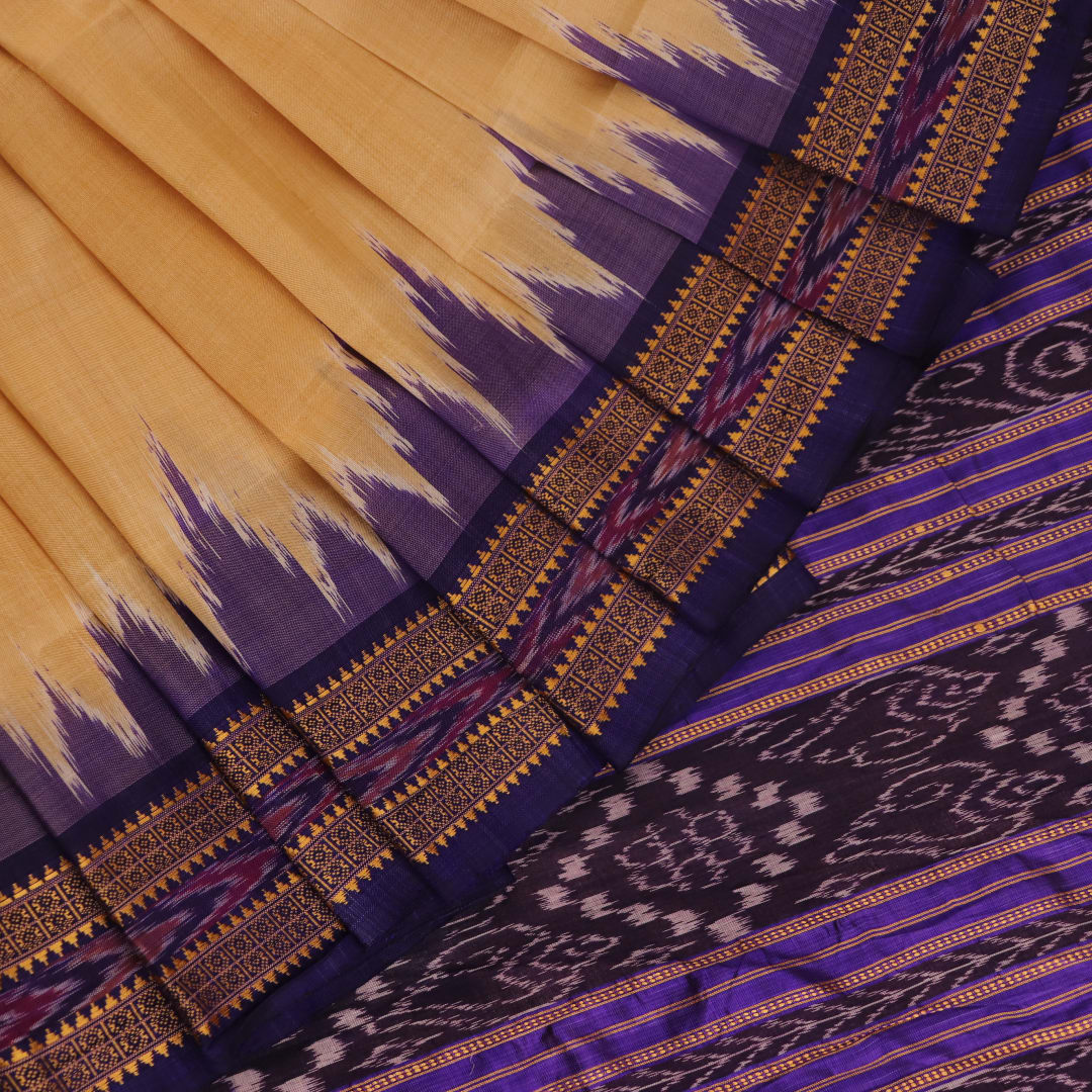 Woman draped in a cream and blue Khandua silk saree with butta pattern, showcasing the elegant drape and styling.
