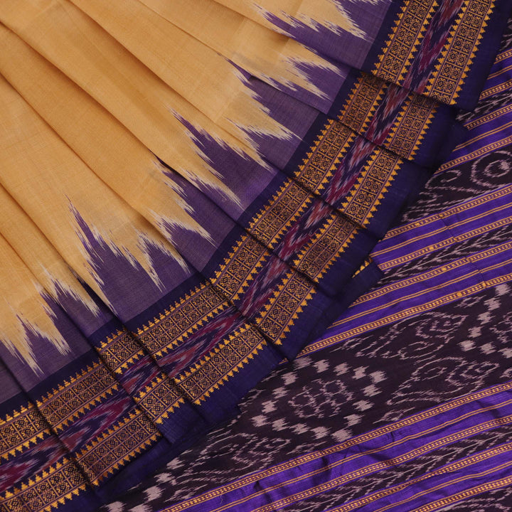 Woman draped in a cream and blue Khandua silk saree with butta pattern, showcasing the elegant drape and styling.