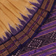 Woman draped in a cream and blue Khandua silk saree with butta pattern, showcasing the elegant drape and styling.