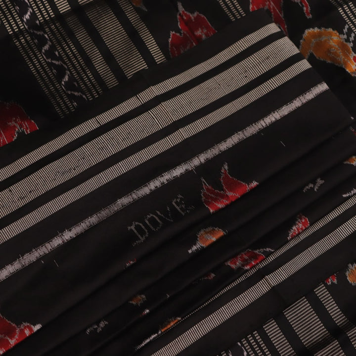 Close-up of the textured silk fabric of a black Sambalpuri saree showing intricate motifs.