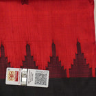 Detailed view of hand-woven silk fabric texture and butta patterns on a red Sambalpuri saree.