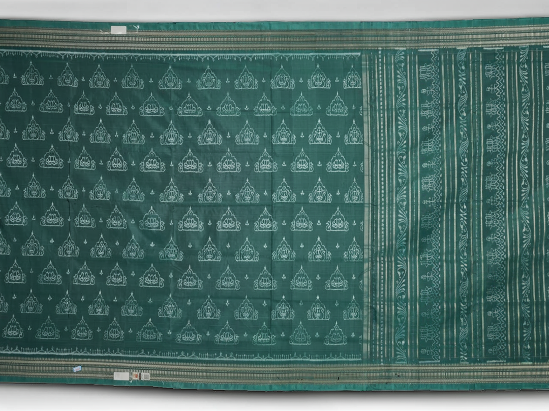 Close-up of green Sambalpuri silk fabric, showing its luxurious texture and fine handloom weave.