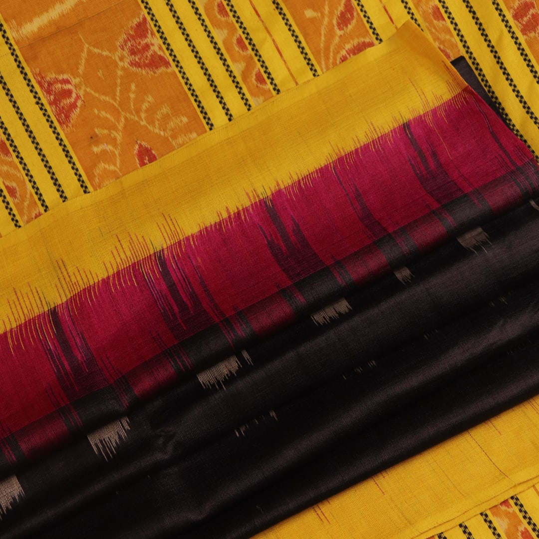 Close-up of black and gold Tussar silk saree fabric with intricate motif patterns