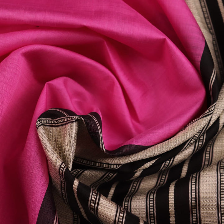 Close-up showcasing the intricate silk fabric texture of a pink and black Berhampuri silk saree with a butta pattern