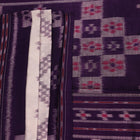 Elegantly draped red and violet Sambalpuri cotton saree with traditional motifs.