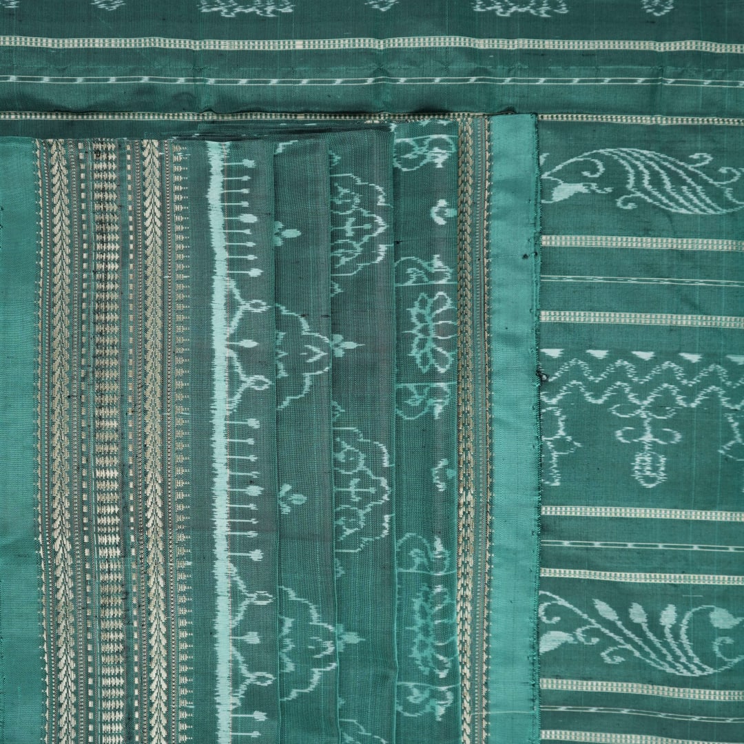 Close-up of green Sambalpuri silk fabric, showing its luxurious texture and fine handloom weave.
