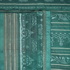 Close-up of green Sambalpuri silk fabric, showing its luxurious texture and fine handloom weave.