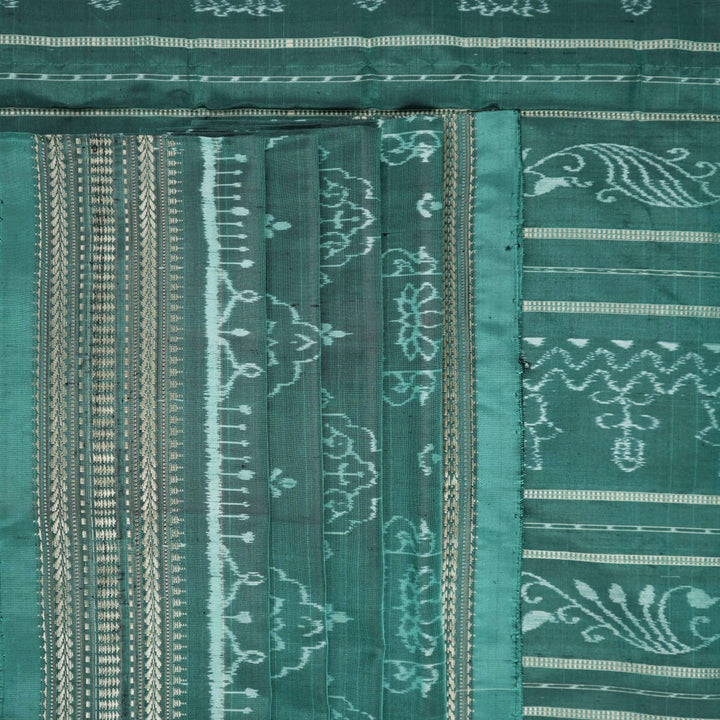 Close-up of green Sambalpuri silk fabric, showing its luxurious texture and fine handloom weave.