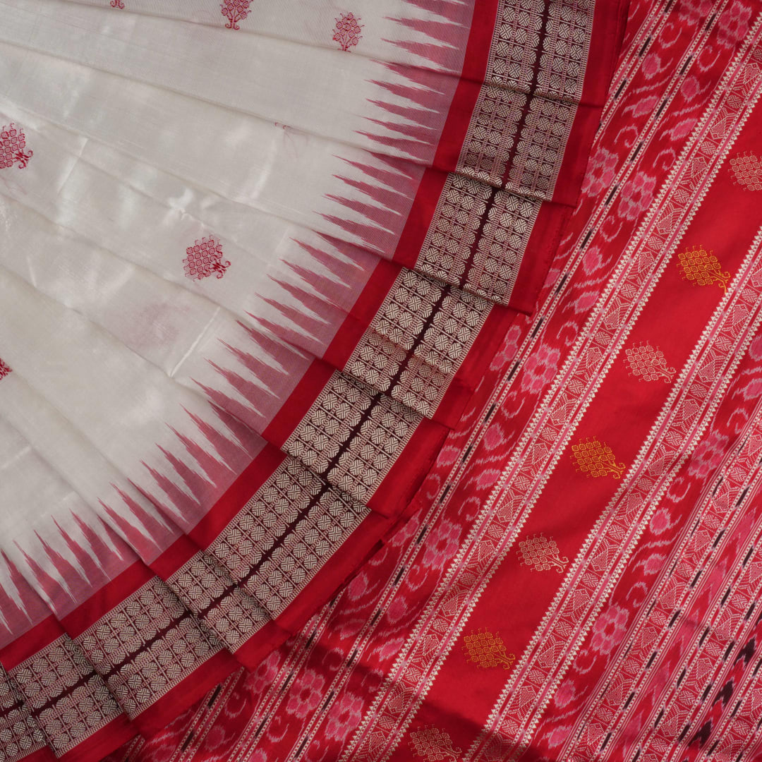 Extreme close-up revealing the rich Bomkai silk fabric texture and intricate handloom weave details in white and red.