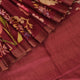 Close-up of maroon Tussar silk saree fabric, emphasizing its distinct texture and printed pattern.