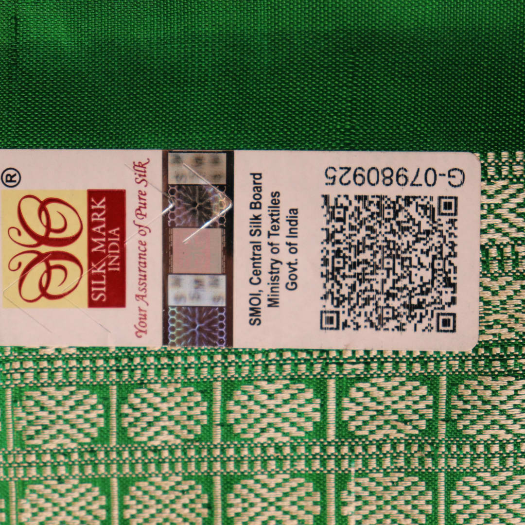 Close-up showcase of the exquisite silk texture with intricate motifs in a black and green Sambalpuri saree.