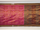 Close-up of Sambalpuri silk fabric texture, highlighting the fine weave in pink and maroon with delicate tissue motifs.