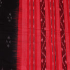 A model drapes a black Sambalpuri cotton dupatta with red motifs and pallu border.