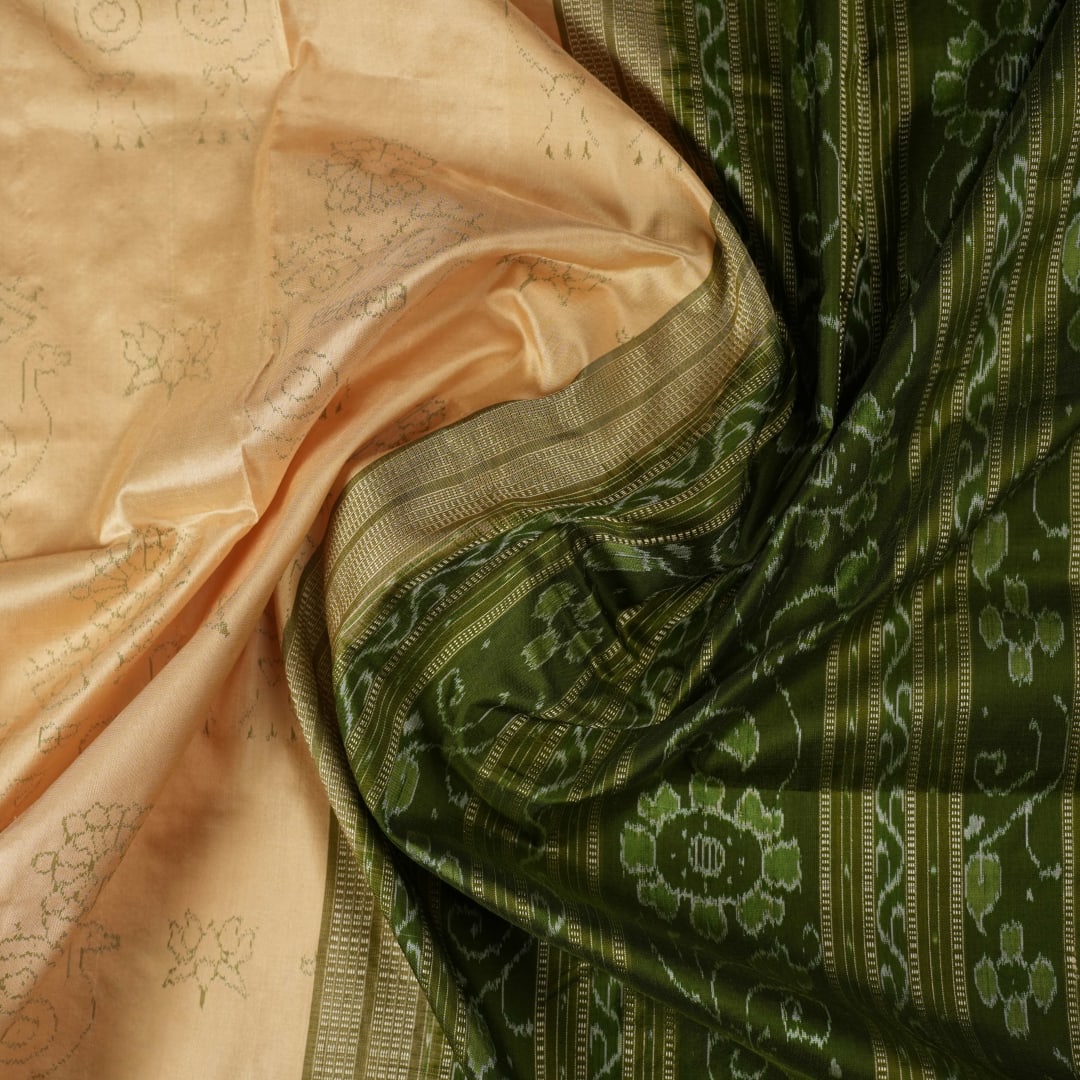 Extreme close-up of cream Sambalpuri silk saree showing exquisite handloom weave texture.