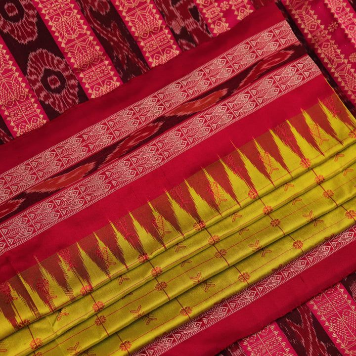 Close-up view of the soft silk fabric texture of a green and magenta Sambalpuri saree with intricate butta patterns