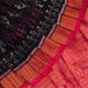 Close-up of black Sambalpuri silk saree fabric texture with subtle motifs and magenta threads.