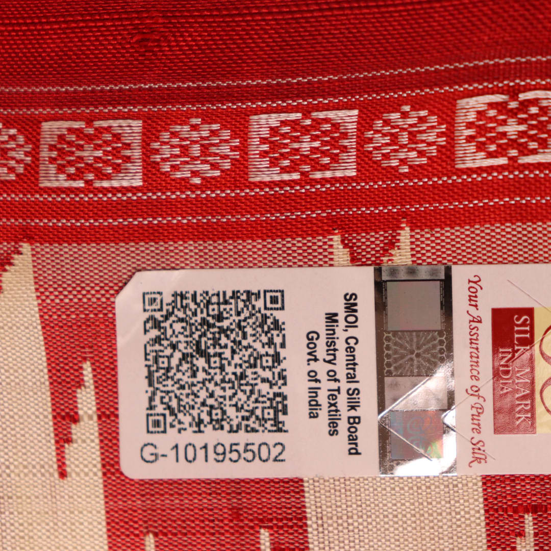 Close-up view of the intricate silk texture on a Berhampuri saree in white with a red border