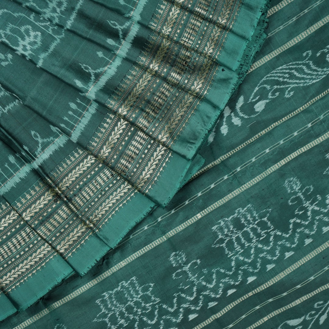 Close-up of green Sambalpuri silk fabric, showing its luxurious texture and fine handloom weave.