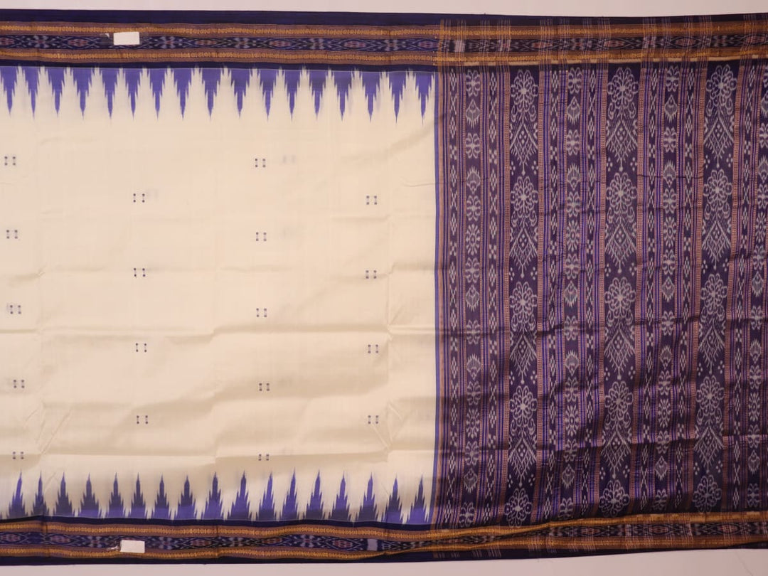 Woman elegantly draped in a white and blue Khandua silk saree with butta pattern.