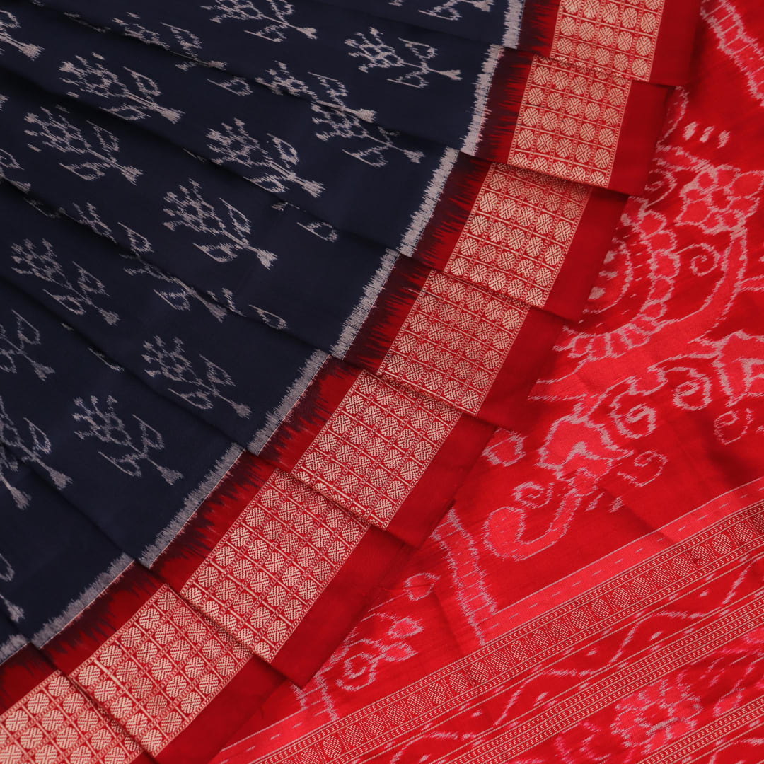 Close-up view of the blue silk Sambalpuri saree's fabric texture showcasing intricate motifs in red