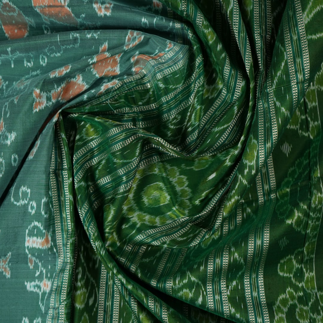 Ultra close-up of green Sambalpuri silk saree fabric, highlighting its luxurious texture and weave.