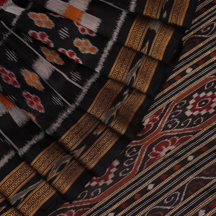 A woman elegantly draping a black silk Khandua Pasapalli saree with a detailed view of the drape and fall of the fabric.