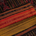 Green and black Khandua silk saree draped; showcasing its butta pattern and elegant fall.