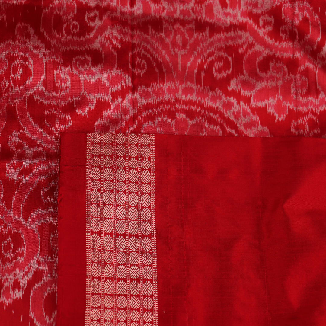 Close-up of grey Sambalpuri silk saree fabric showing intricate motif texture.