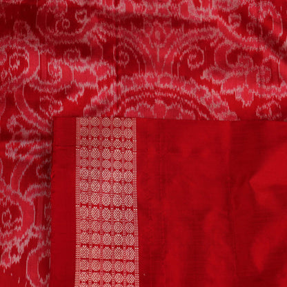 Close-up of grey Sambalpuri silk saree fabric showing intricate motif texture.