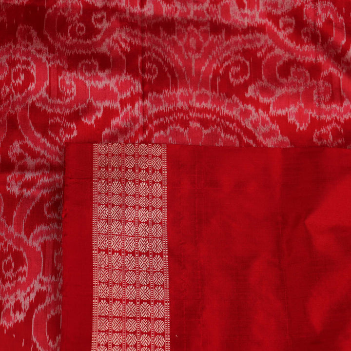 Close-up of grey Sambalpuri silk saree fabric showing intricate motif texture.
