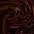 A brown and red Bomkai cotton saree with butta pattern on display
