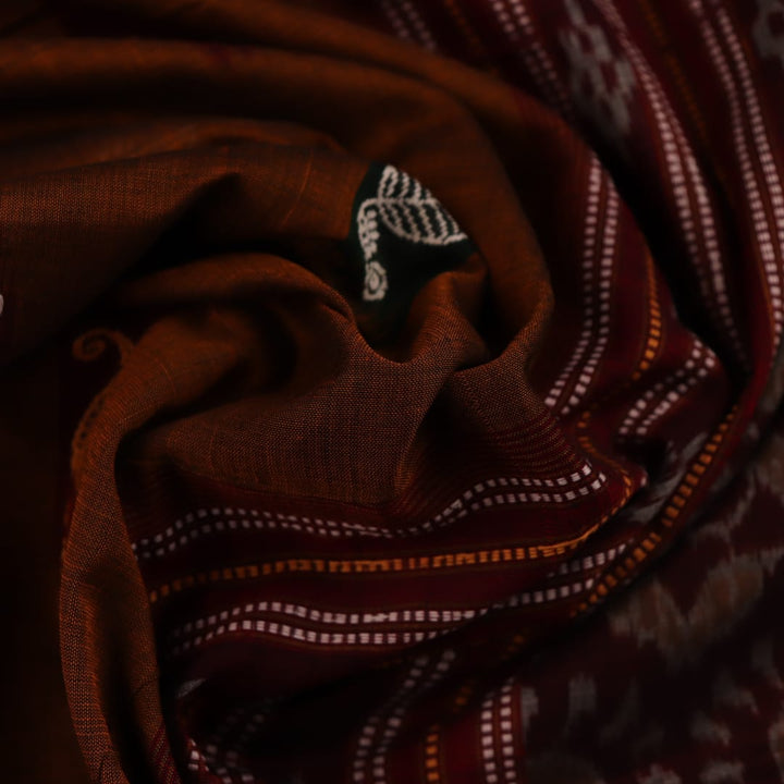 A brown and red Bomkai cotton saree with butta pattern on display