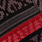 Red and black Sambalpuri cotton saree with motifs, elegantly draped.