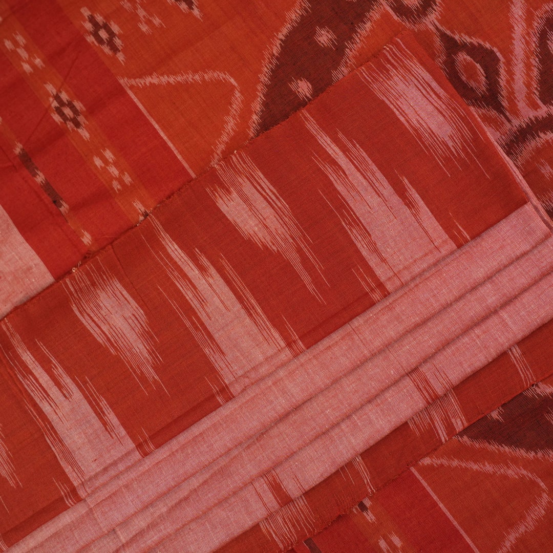 Professional styling view of a rust Sambalpuri cotton saree draped on a model for an elegant ethnic look.