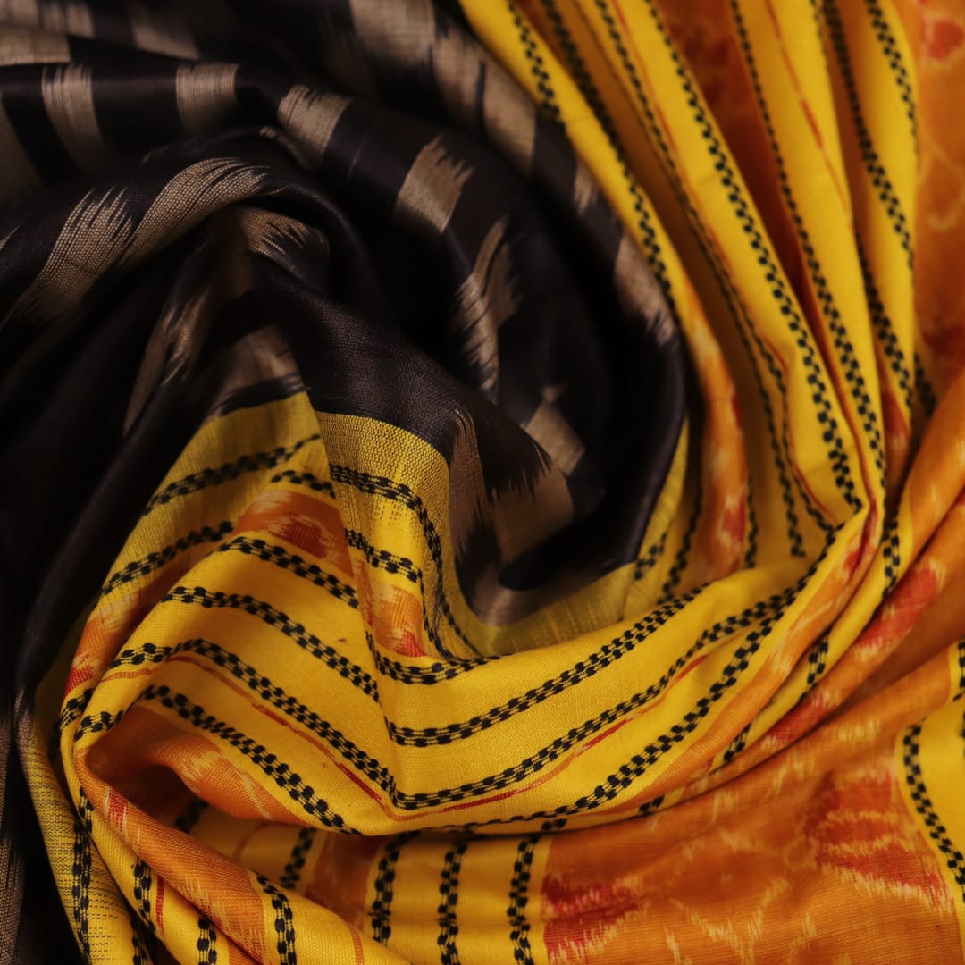 Close-up of black and gold Tussar silk saree fabric with intricate motif patterns