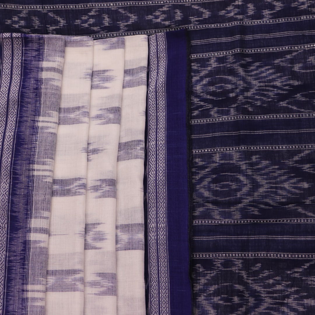 Model wearing a white Sambalpuri cotton saree with blue motifs, showcasing the drape and overall look.