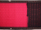 Pink and black cotton Sambalpuri saree with intricate motifs draped in a traditional style.