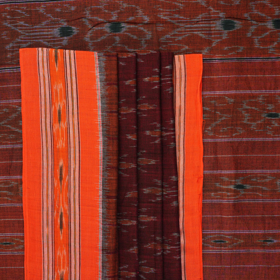 Model draped in a maroon and orange Sambalpuri cotton saree showcasing traditional handloom motifs.