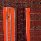 Model draped in a maroon and orange Sambalpuri cotton saree showcasing traditional handloom motifs.