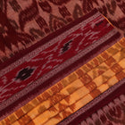 Yellow and maroon Sambalpuri cotton saree with motifs, draped elegantly to showcase its design.