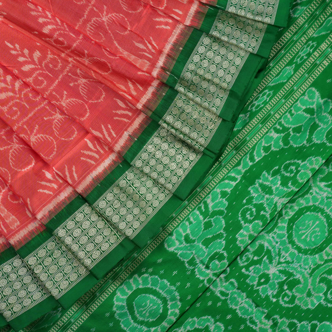 Close-up of the smooth, rich silk texture of the peach Sambalpuri saree with fine motifs.